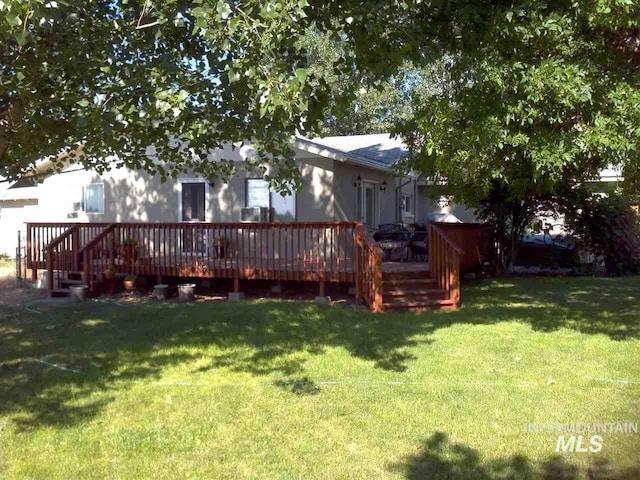 rear view of house with a yard and a deck