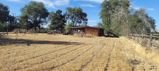 view of yard with an outdoor structure and a rural view