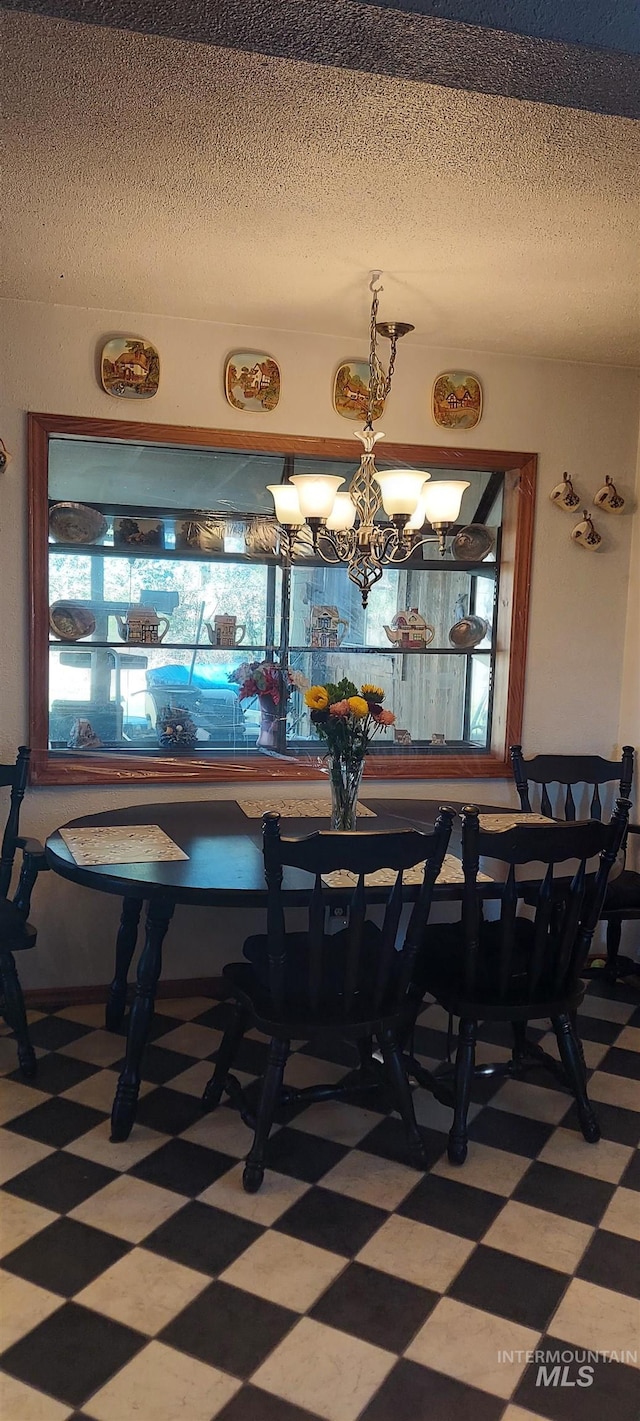 dining space with an inviting chandelier and a textured ceiling