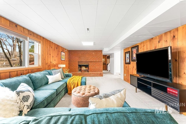 living room with a brick fireplace, carpet flooring, and wooden walls