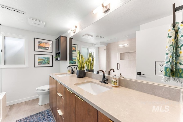 bathroom with double vanity, a stall shower, visible vents, and a sink