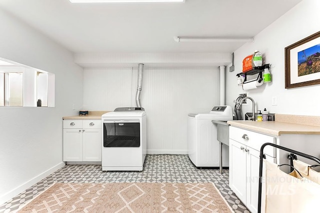 laundry room featuring baseboards, cabinet space, washer and clothes dryer, and light floors