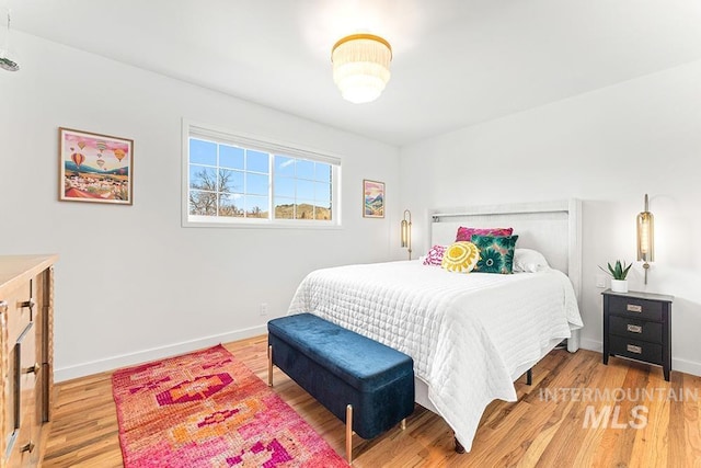 bedroom with baseboards and light wood finished floors