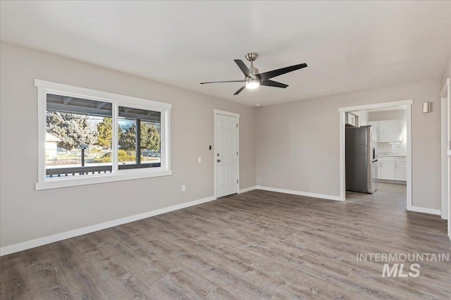 empty room with hardwood / wood-style floors and ceiling fan