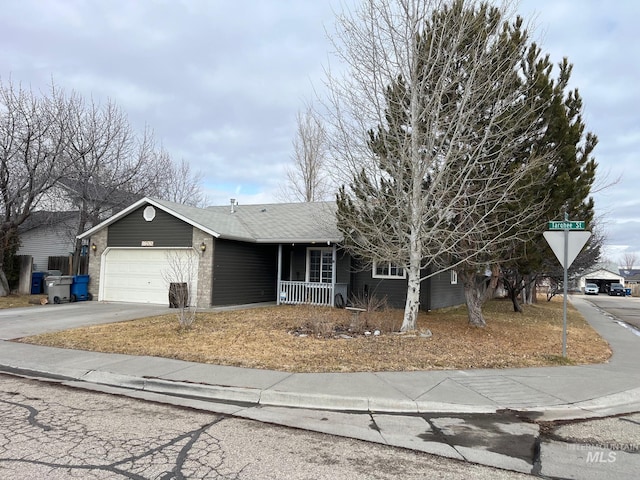 view of front of home with a porch, concrete driveway, and a garage