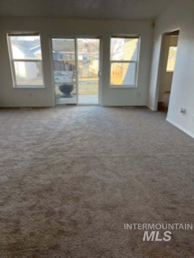 carpeted empty room with vaulted ceiling