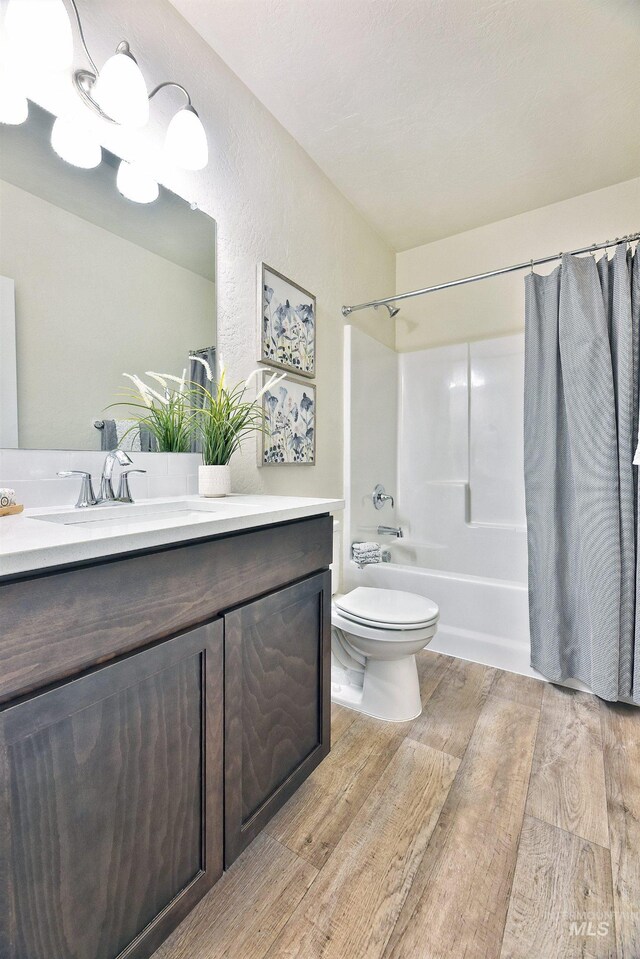 full bathroom with toilet, shower / bath combo with shower curtain, vanity, and wood-type flooring