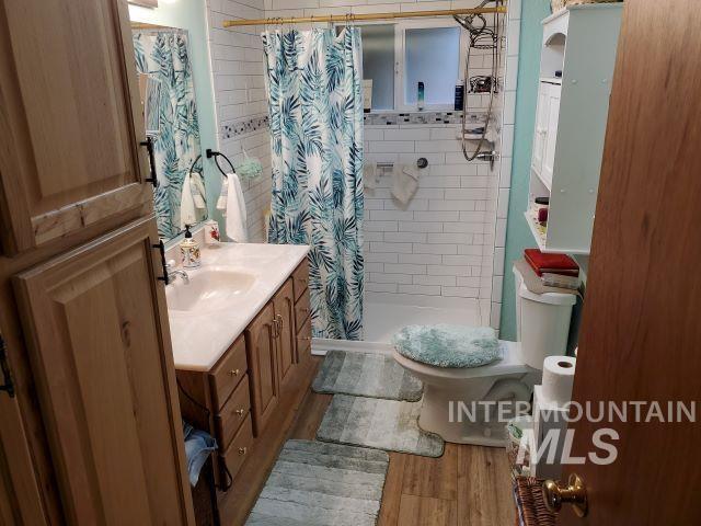 3460 American River Rd, Elk City, ID 83525 - full bathroom with toilet, a shower stall, wood finished floors, and vanity
