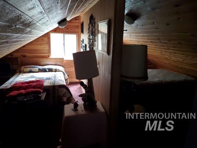 3460 American River Rd, Elk City, ID 83525 - bedroom featuring wooden walls and vaulted ceiling