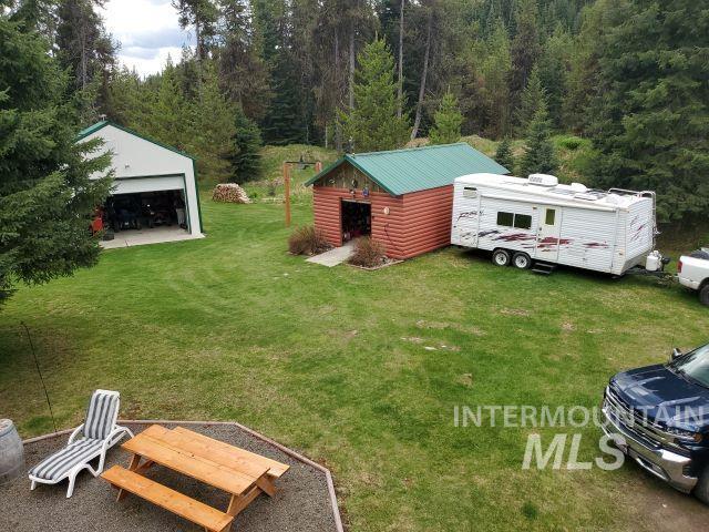 3460 American River Rd, Elk City, ID 83525 - view of yard with a detached garage, an outbuilding, and a wooded view