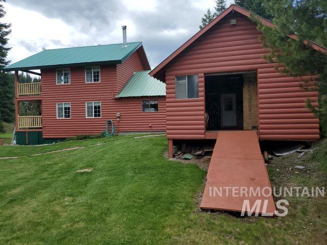3460 American River Rd, Elk City, ID 83525 - back of house with faux log siding, a yard, metal roof, and a balcony