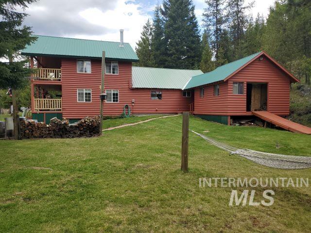 3460 American River Rd, Elk City, ID 83525 - rear view of house with a lawn, a balcony, log veneer siding, and metal roof