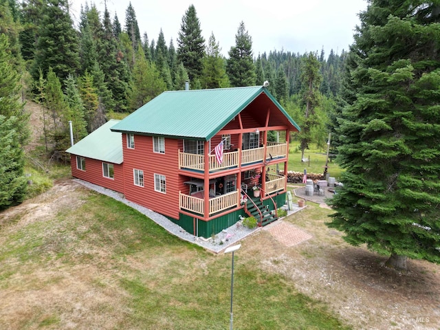 3460 American River Rd, Elk City, ID 83525 - back of property with faux log siding, a deck, a view of trees, a yard, and metal roof