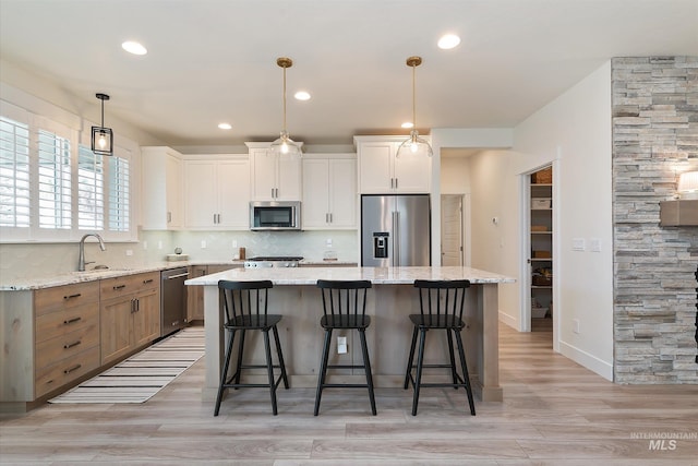 6009 W Riva Capri St, Meridian, ID 83646 - kitchen featuring a sink, decorative backsplash, a breakfast bar, appliances with stainless steel finishes, and a kitchen island