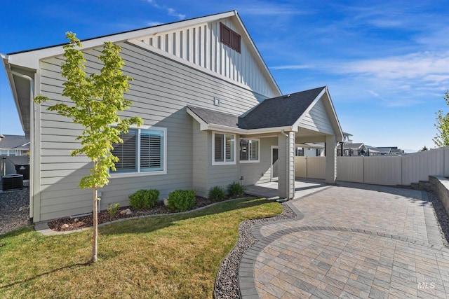 6009 W Riva Capri St, Meridian, ID 83646 - view of front of home with fence, cooling unit, board and batten siding, a patio, and a front yard