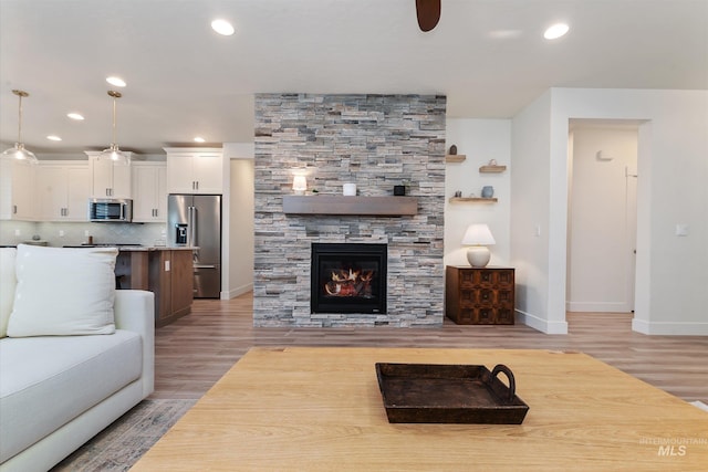 6009 W Riva Capri St, Meridian, ID 83646 - living area featuring recessed lighting, a stone fireplace, a ceiling fan, baseboards, and light wood-style flooring