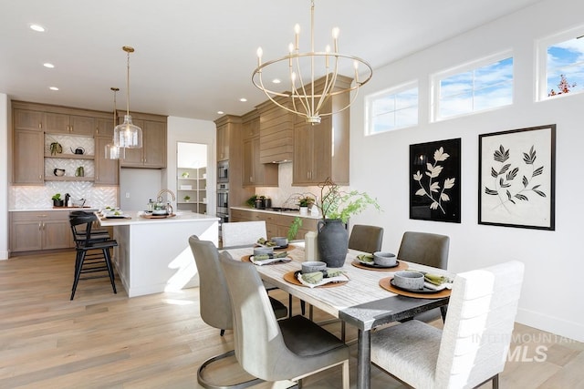 dining room with light hardwood / wood-style flooring, a notable chandelier, and sink