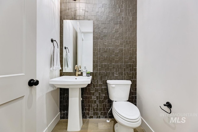 bathroom featuring tile walls, toilet, and tile patterned floors