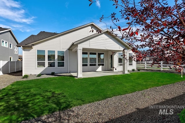 rear view of house with a patio and a yard