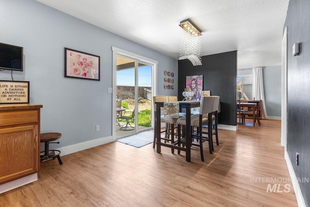 16042 N Saint Helens Dr, Nampa, ID 83651 - dining space with baseboards, a textured ceiling, and light wood-style floors
