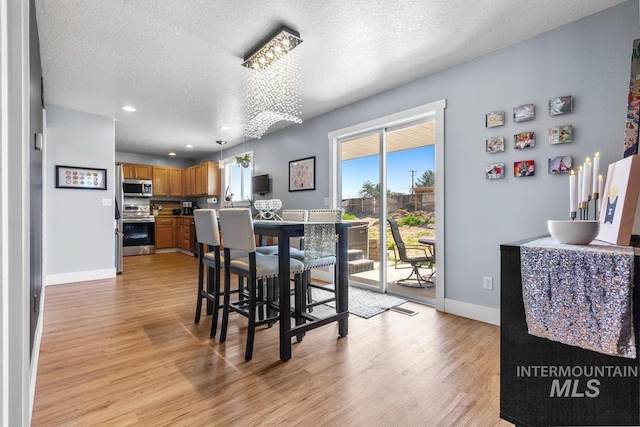 16042 N Saint Helens Dr, Nampa, ID 83651 - dining area featuring light wood finished floors, baseboards, and a textured ceiling