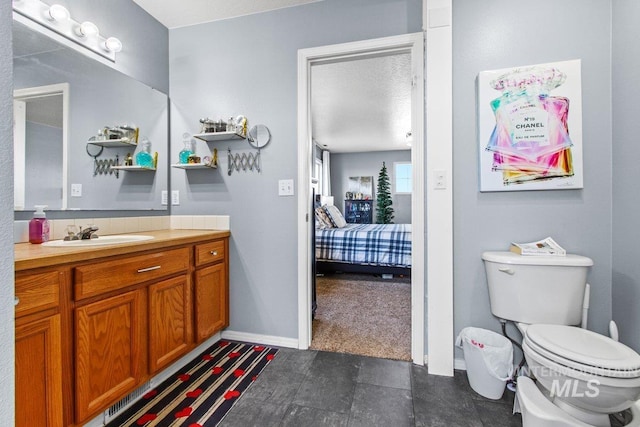 16042 N Saint Helens Dr, Nampa, ID 83651 - bathroom with baseboards, toilet, vanity, and ensuite bathroom