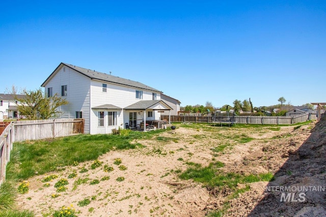 16042 N Saint Helens Dr, Nampa, ID 83651 - rear view of property with a trampoline and a fenced backyard