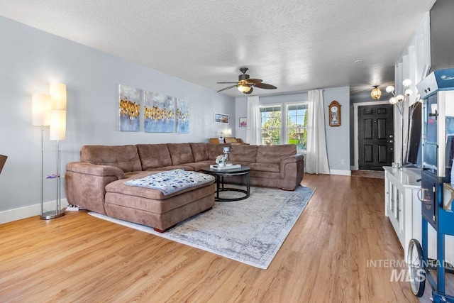 16042 N Saint Helens Dr, Nampa, ID 83651 - living area with light wood-style flooring, baseboards, a textured ceiling, and a ceiling fan