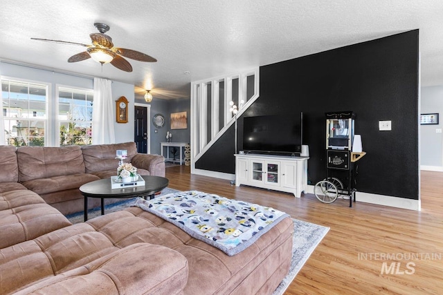 16042 N Saint Helens Dr, Nampa, ID 83651 - living room featuring wood finished floors, a textured ceiling, baseboards, and ceiling fan