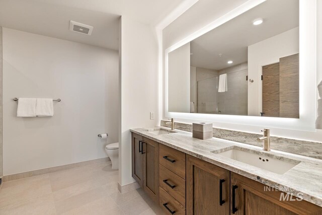 bathroom featuring vanity, an enclosed shower, tile patterned flooring, and toilet