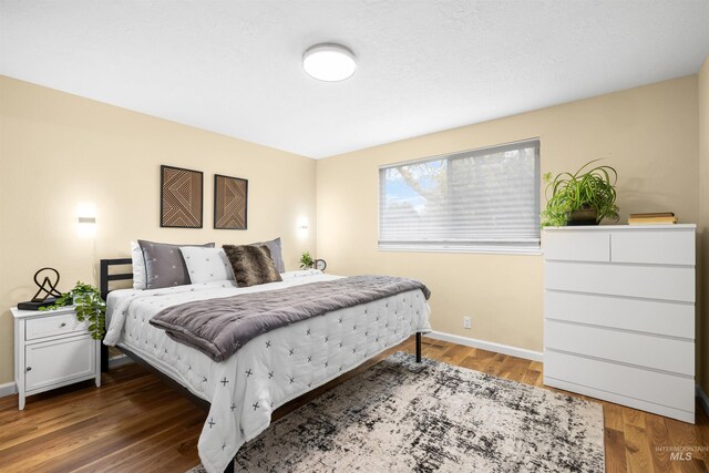 bedroom featuring baseboards and wood finished floors