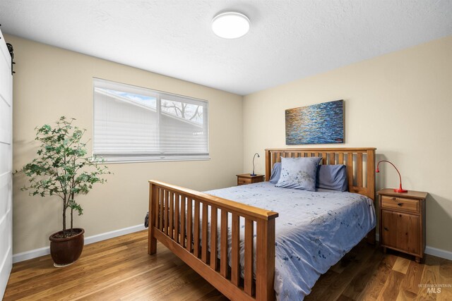 bedroom featuring baseboards and wood finished floors