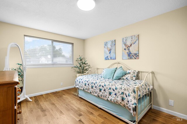bedroom featuring baseboards and wood finished floors