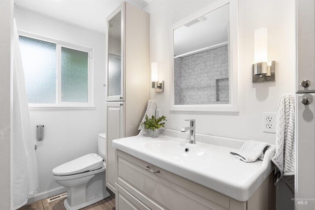 full bathroom with toilet, visible vents, and vanity
