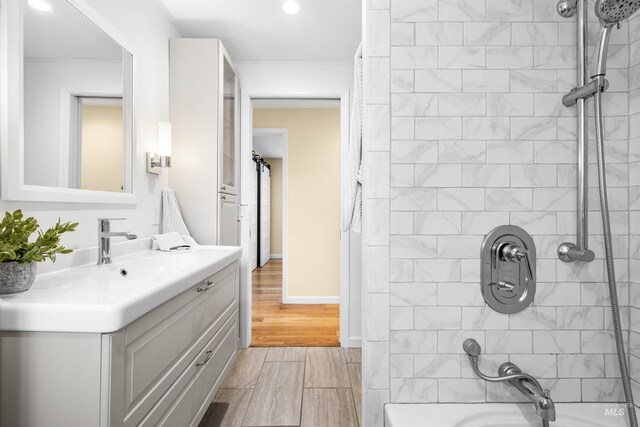 full bathroom with wood finished floors, vanity, baseboards, shower / bathtub combination, and recessed lighting