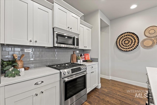 kitchen featuring white cabinets, backsplash, dark hardwood / wood-style floors, and stainless steel appliances