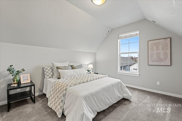 bedroom featuring a textured ceiling, carpet flooring, and lofted ceiling