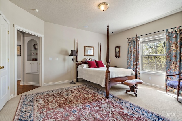 bedroom with baseboards, carpet flooring, and a textured ceiling
