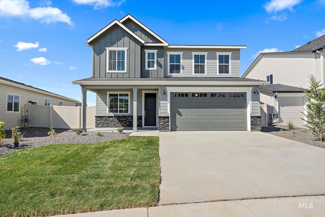 craftsman inspired home featuring board and batten siding, fence, a porch, concrete driveway, and stone siding