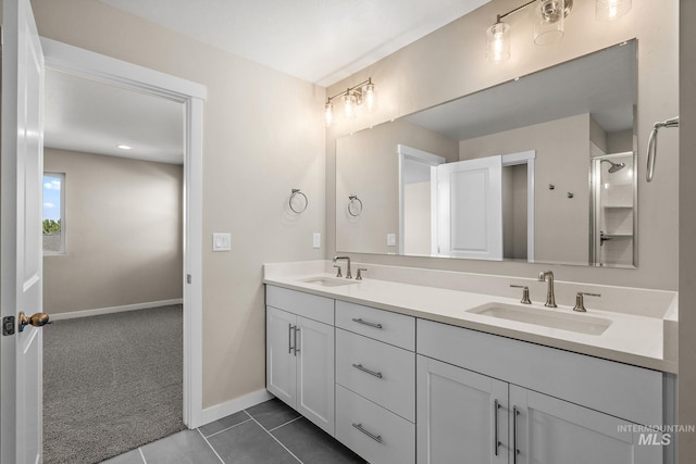 full bath with double vanity, baseboards, tile patterned floors, and a sink