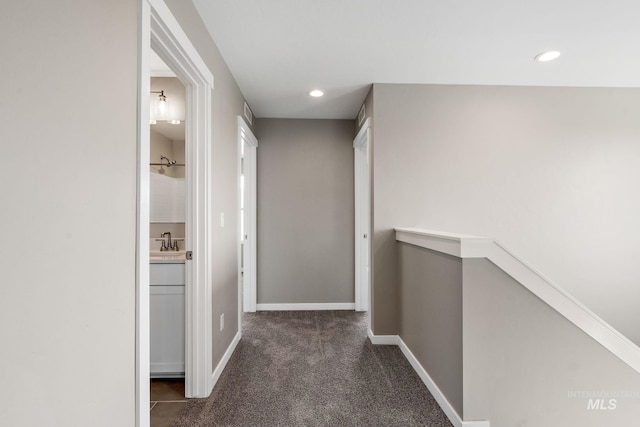 hall with baseboards, an upstairs landing, carpet flooring, recessed lighting, and a sink