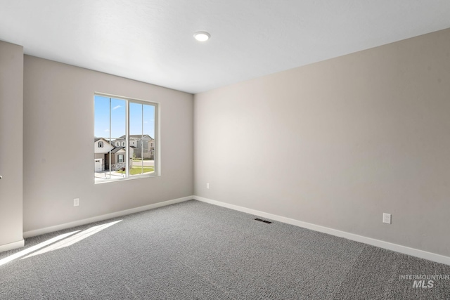 carpeted empty room with visible vents and baseboards