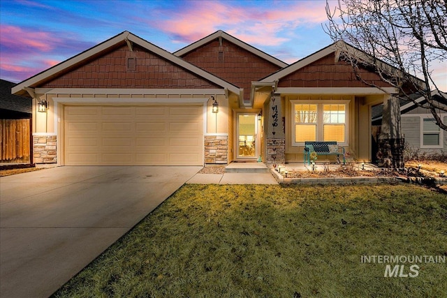 craftsman house featuring a garage, fence, driveway, stone siding, and a lawn