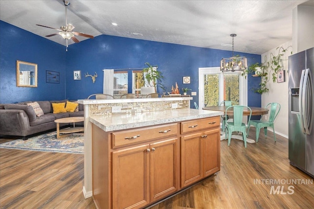 kitchen featuring lofted ceiling, open floor plan, and stainless steel fridge with ice dispenser