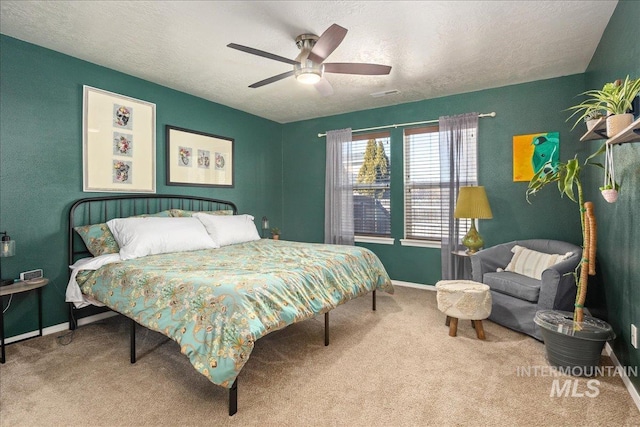 carpeted bedroom featuring visible vents, ceiling fan, a textured ceiling, and baseboards