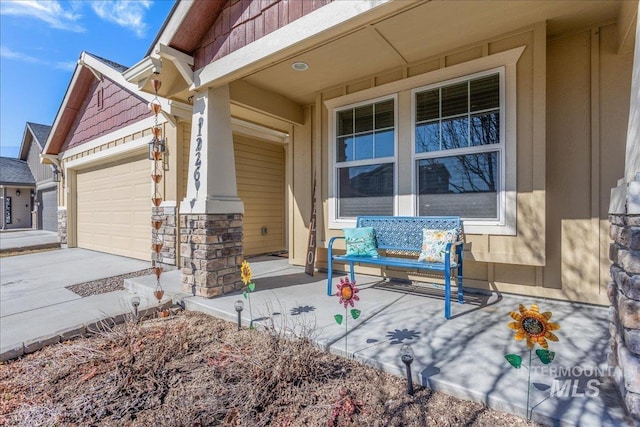 view of patio / terrace with concrete driveway, a porch, and an attached garage