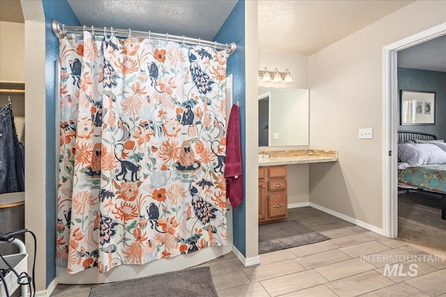 full bath with a textured ceiling, vanity, baseboards, wood tiled floor, and shower / bath combo with shower curtain