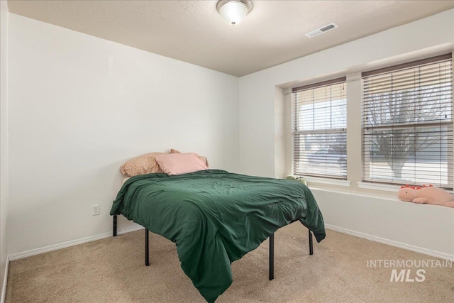 carpeted bedroom with visible vents and baseboards