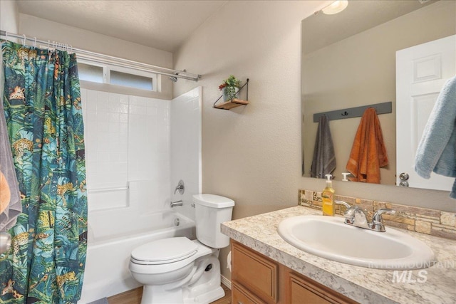 bathroom featuring toilet, shower / bathtub combination with curtain, a textured ceiling, and vanity