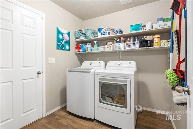 washroom featuring wood finished floors, laundry area, baseboards, and separate washer and dryer